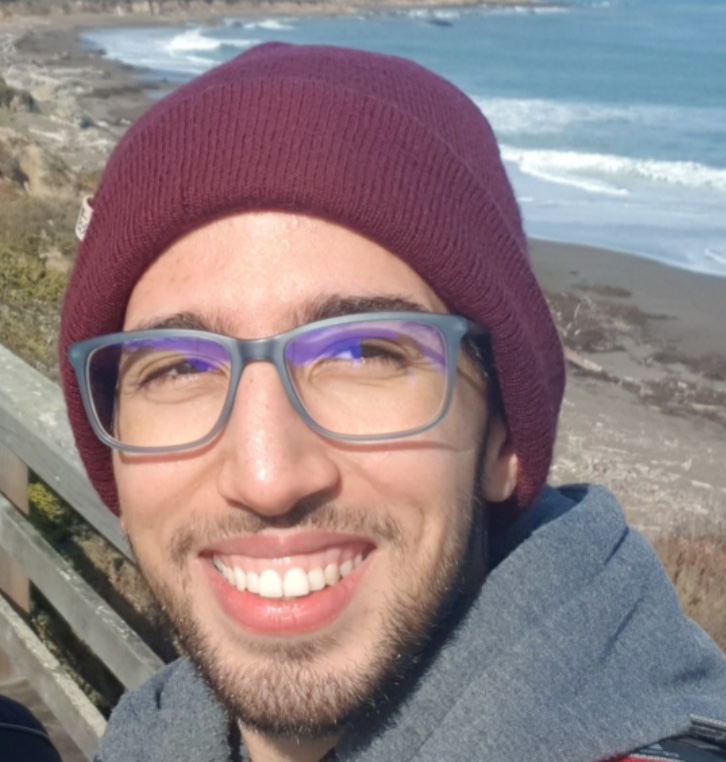 portrait of Farouk Ghodhbane smiling with ocean view in the back